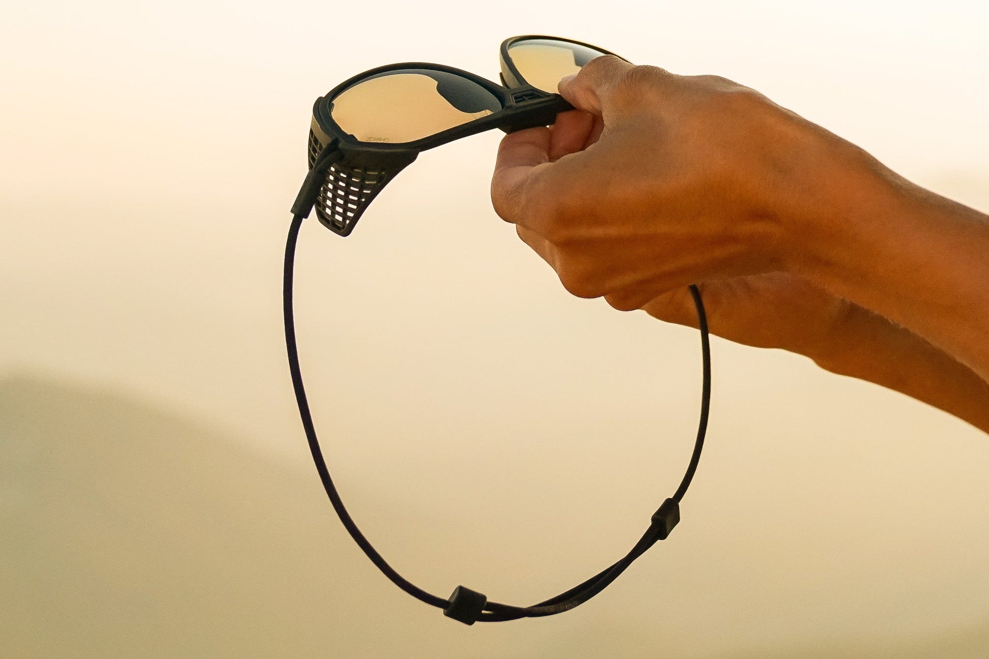 Tortoise_grey Spinning man wearing Ombraz classic tortoise grey armless sunglasses with cord