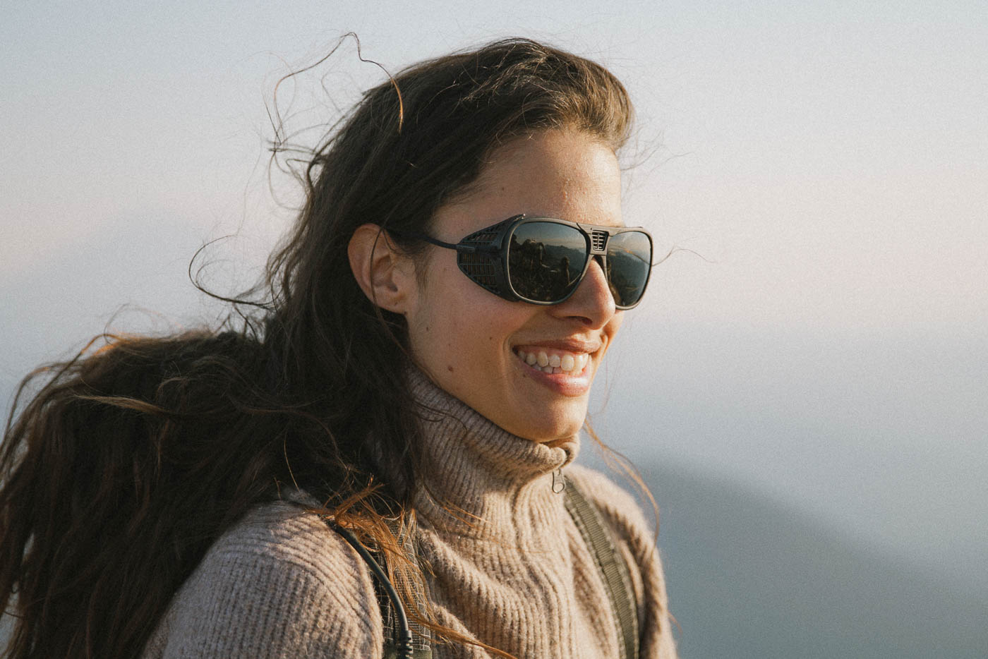 Tortoise_grey Woman in a car wearing Ombraz classic armless strap sunglasses