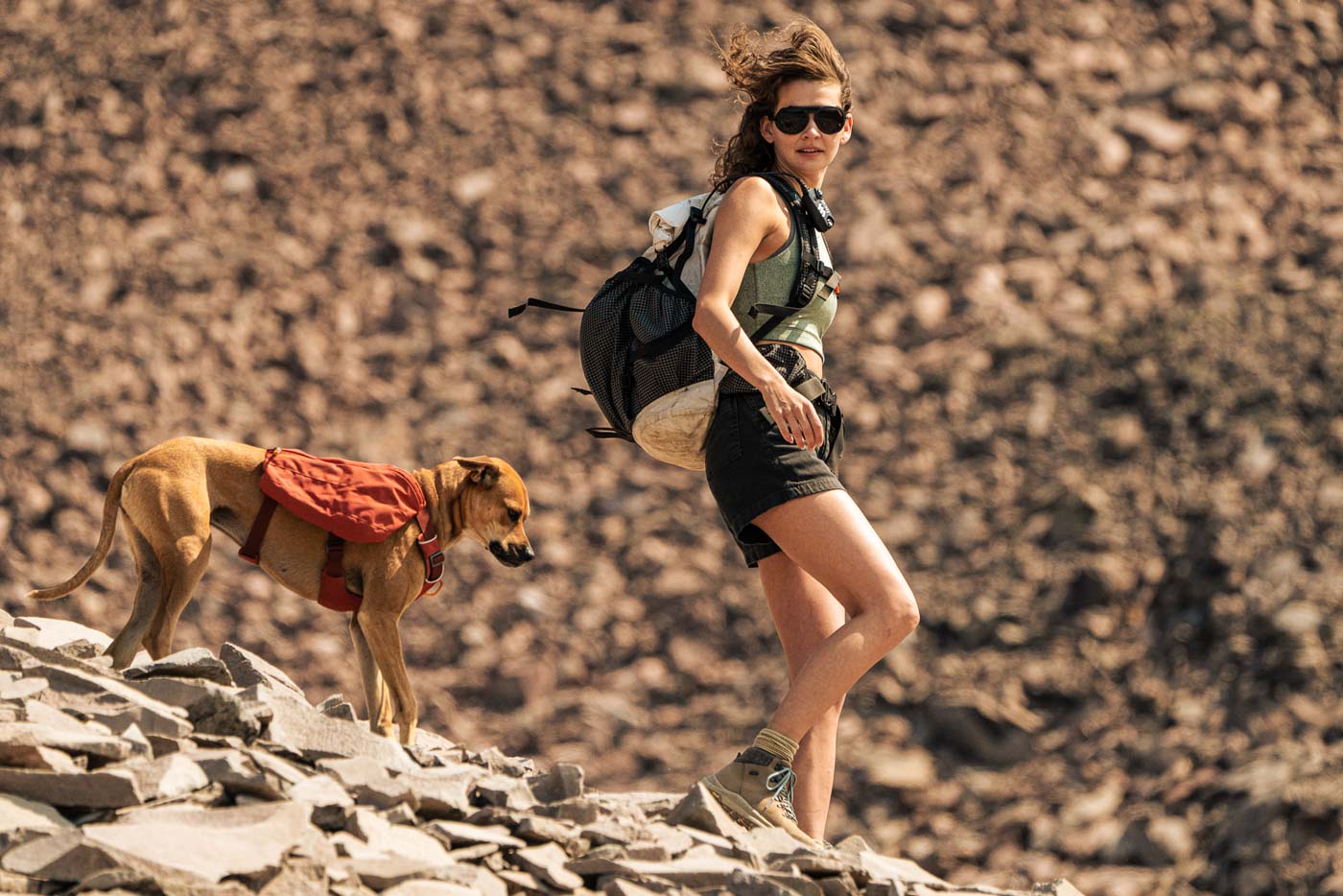 black_ice_silver_mirror Woman walking down a mountain with her dog sporting Ombraz unisex armless string sunglasses