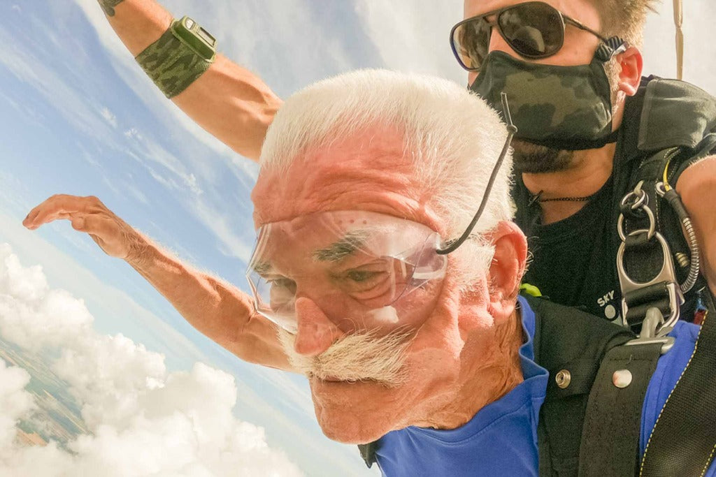 MATTEBROWN_GREY Man skydiving with an older man wearing Ombraz classic armless string sunglasses