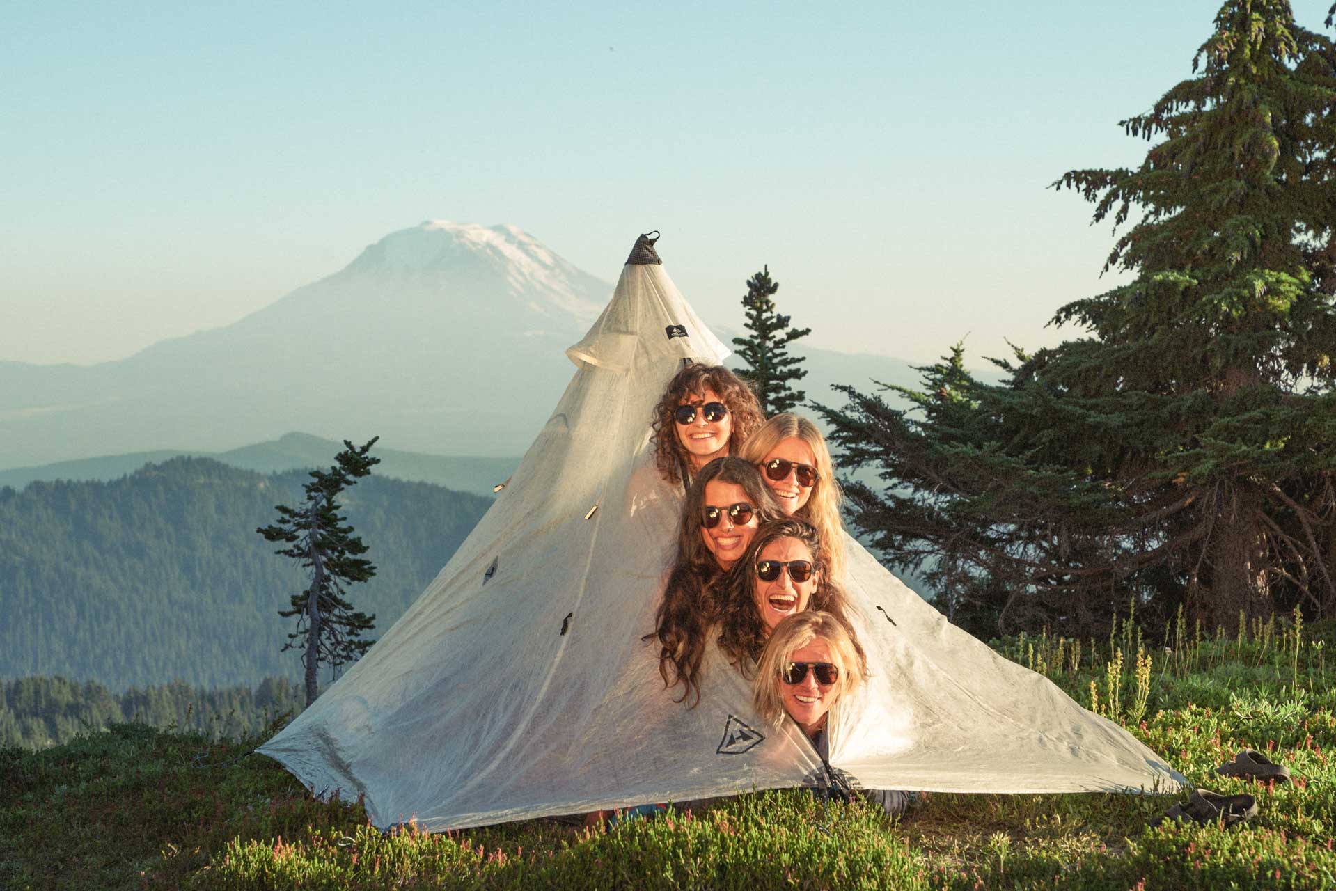 teton_charcoal_brown Group of people with their heads sticking out of a tent wearing Ombraz armless string sunglasses