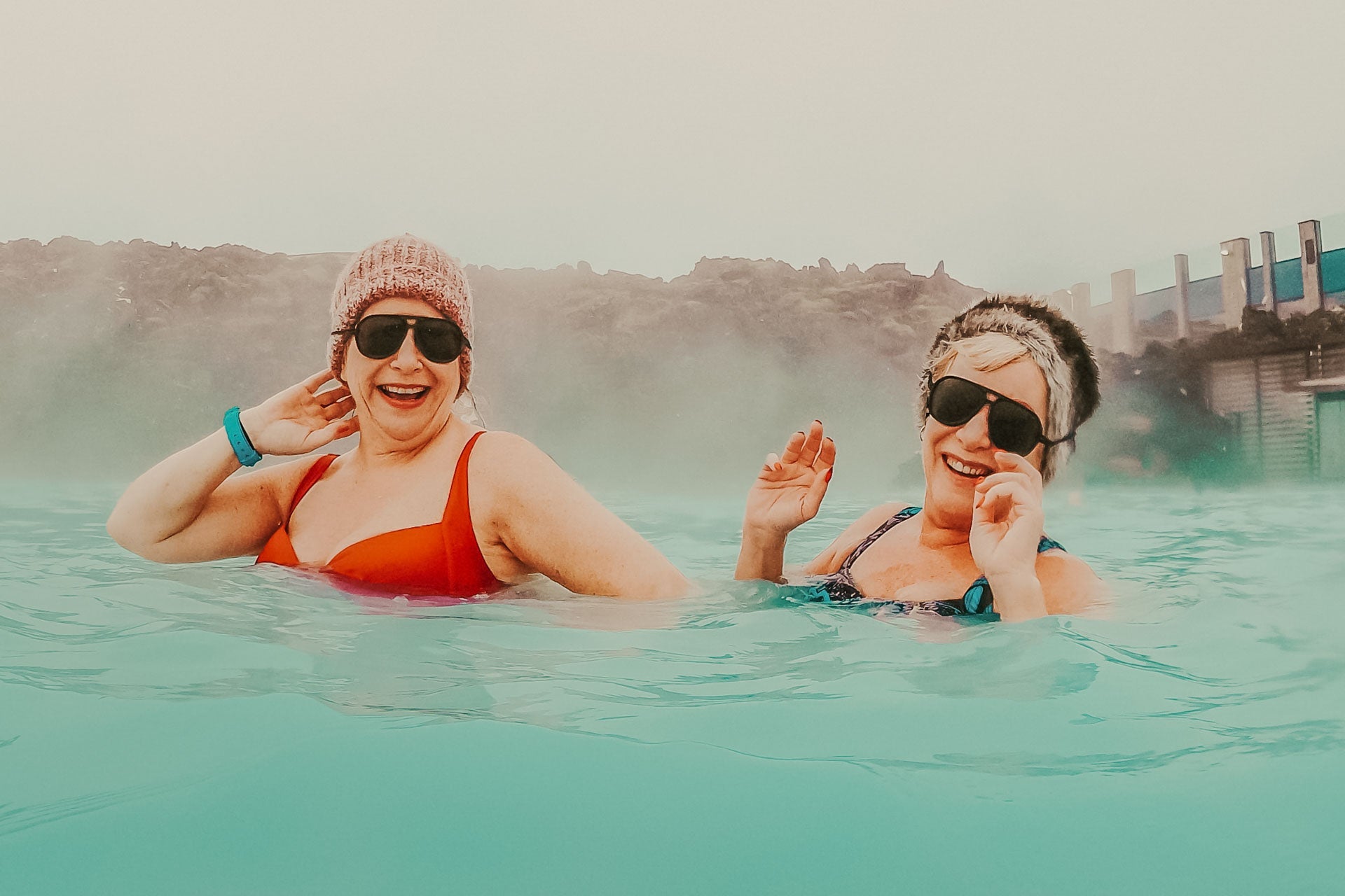 charcoal_brown Two women sitting in the blue lagoon wearing Ombraz armless string sunglasses