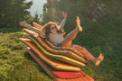 viale_charcoal_grey Woman laying on pool floaties outside wearing Ombraz viale armless string sunglasses