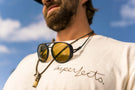 dolomite_charcoal_yellow Upward shot of man wearing Ombraz armless strap sunglasses over his chain