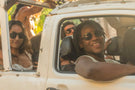 dolomite_slate_grey Smiling group of friends wearing Ombraz string sunglasses with strap sitting in a car
