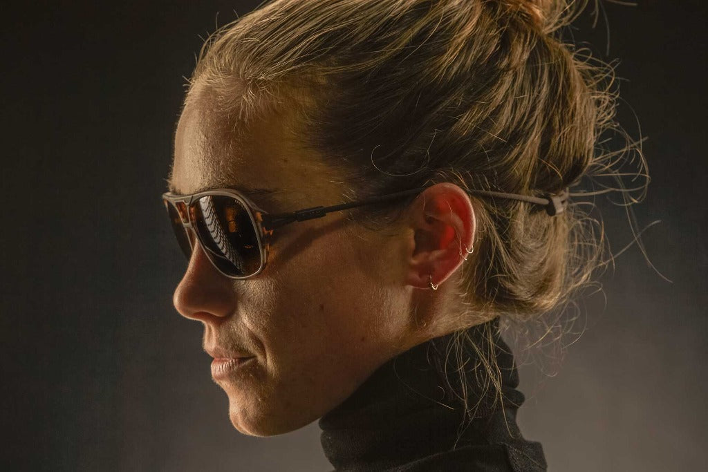 ember_grey Side shot of woman wearing Ombraz leggero armless strap sunglasses
