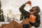 leggero_charcoal_brown Man eating spaghetti in the snow wearing Ombraz leggero armless sunglasses with strap