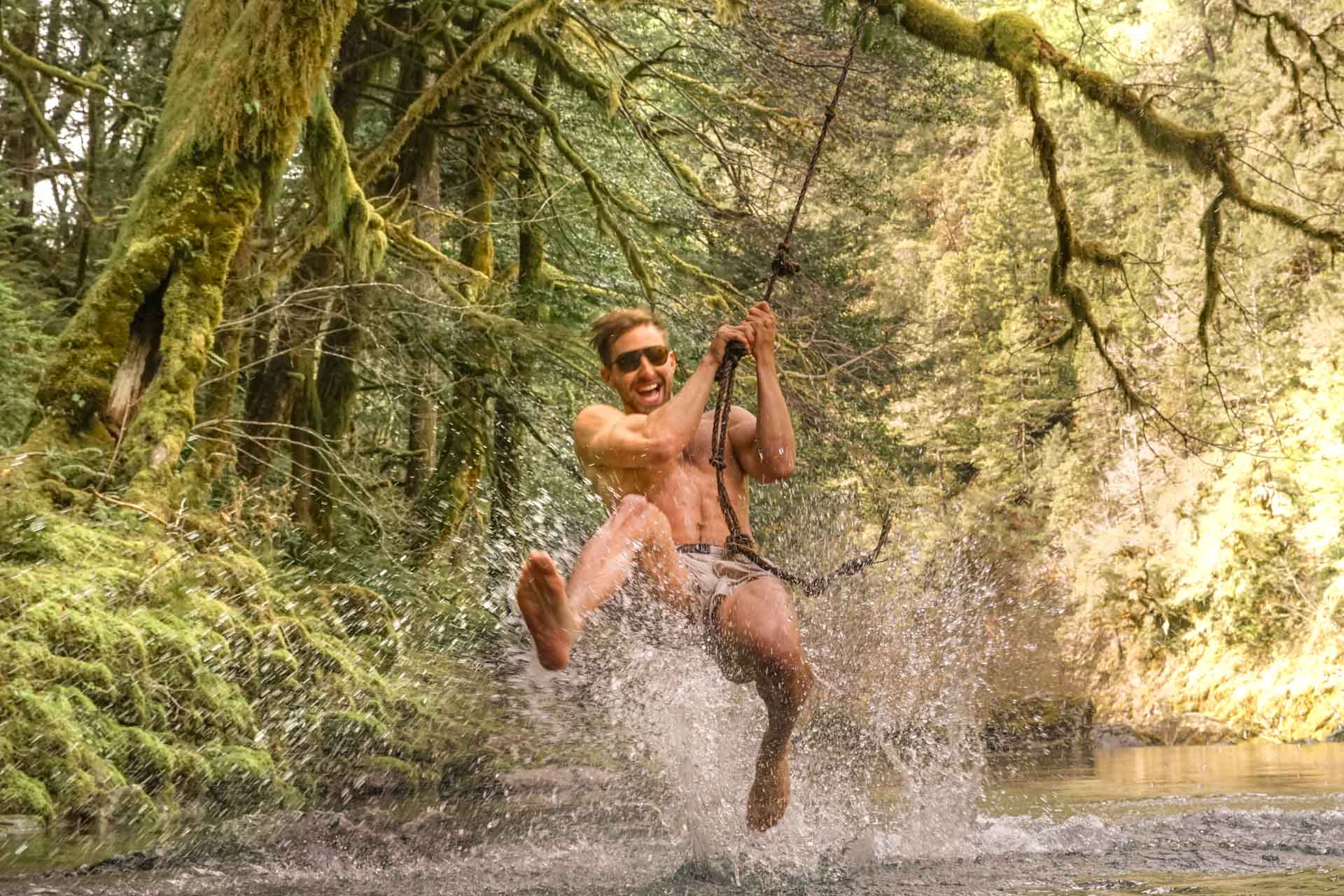 mattebrown_grey Man on a rope swing in a river wearing Ombraz classic armless strap sunglasses