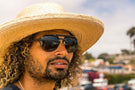 dolomite_slate_grey Bearded man wearing a hat and Ombraz dolomite armless rope sunglasses