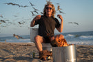 Man on a toilet on the beach wearing Ombraz teton armless rope sunglasses teton_tortoise_brown