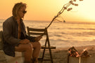 Man roasting marshmallows sitting on a toilet on the beach wearing Ombraz armless string sunglasses TETON_TORTOISE_YELLOW