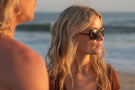 TETON_TORTOISE_YELLOW  Woman on the beach looking into the distance wearing Ombraz teton armless strap sunglasses