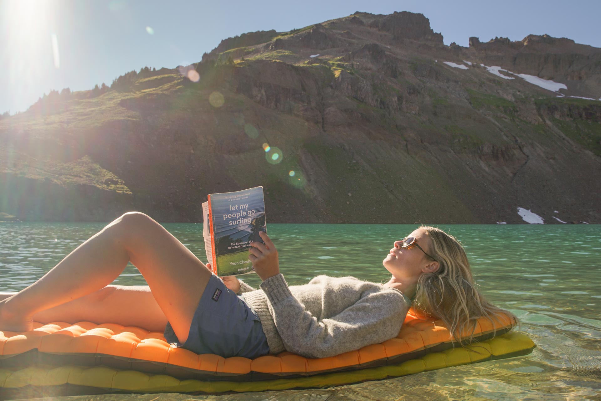 viale_tortoise_brown Woman floating in a lake reading a book wearing Ombraz viale unisex armless string sunglasses