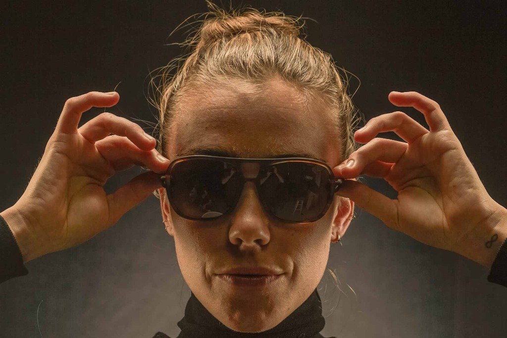 leggero_tortoise_grey Headshot of woman adjusting her Ombraz armless sunglasses with strap