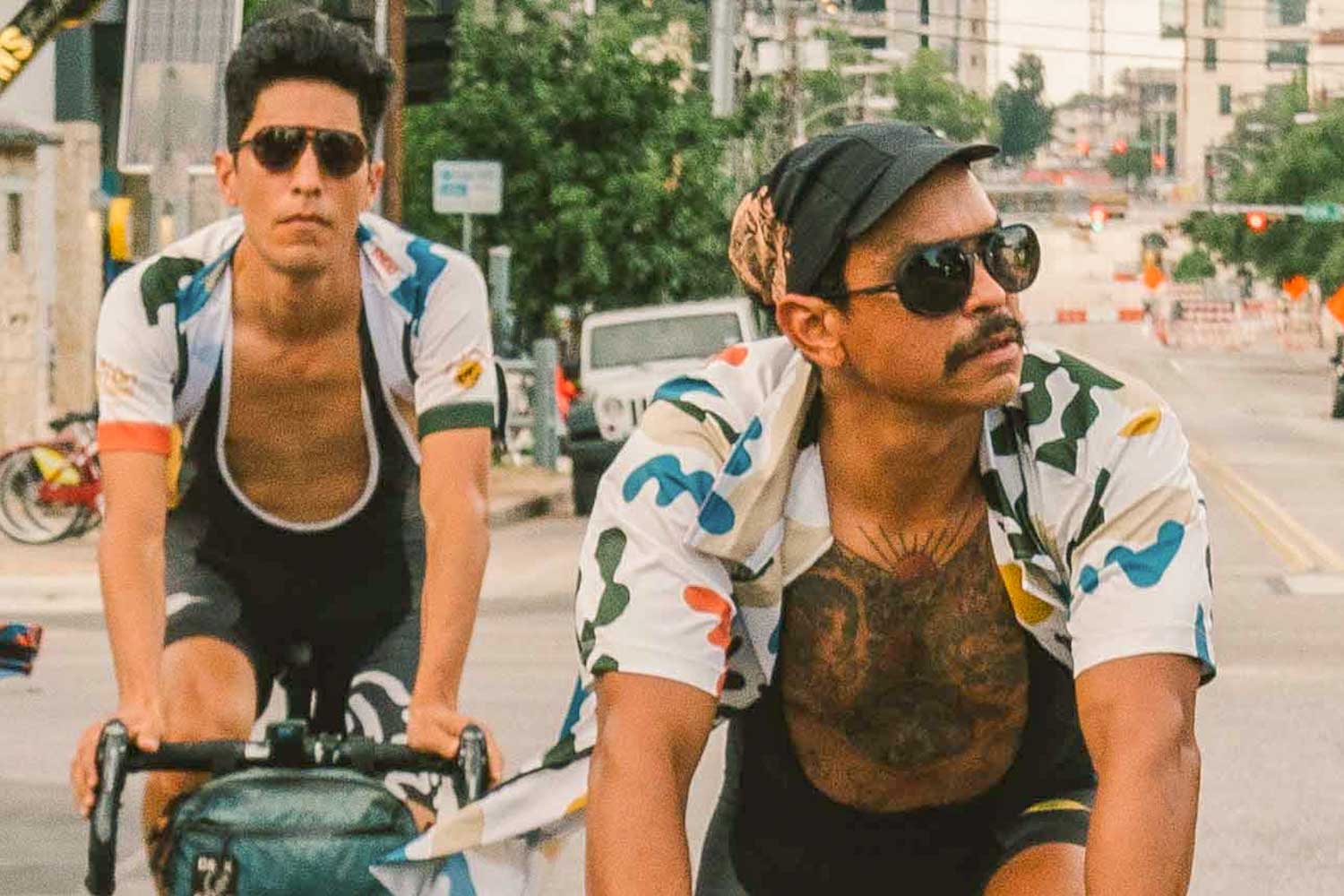 Tortoise_grey Two guys biking in the city wearing Ombraz classic armless rope sunglasses