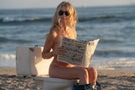 VIALE_DUSK_GREY Woman on a toilet on the beach wearing Ombraz armless string sunglasses