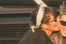 VIALE_TORTOISE_BROWN Woman kissing a man wearing Ombraz armless string sunglasses