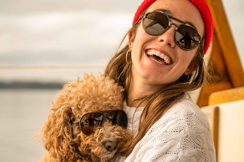 dolomite_slate_brown Smiling woman and her dog both wearing Ombraz armless string sunglasses